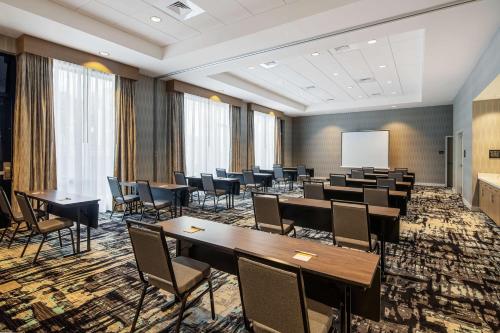 a conference room with tables and chairs and a whiteboard at Hampton Inn & Suites Raleigh Midtown, NC in Raleigh