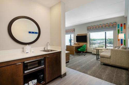 a bathroom with a sink and a mirror in a room at Hampton Inn & Suites Raleigh Midtown, NC in Raleigh