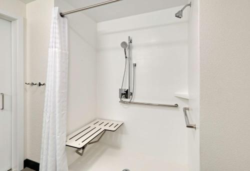 a bathroom with a shower curtain and a bench at Hampton Inn by Hilton Irvine Spectrum Lake Forest in Lake Forest