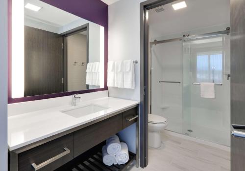 W łazience znajduje się umywalka, toaleta i lustro. w obiekcie Homewood Suites By Hilton Irvine Spectrum Lake Forest w mieście Lake Forest