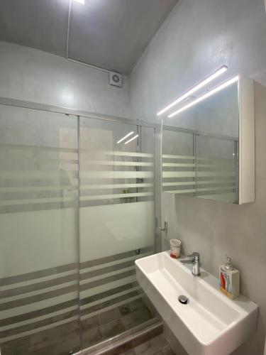 a bathroom with a sink and a glass shower at Syrona in Posidhonía