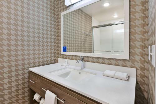 a bathroom with a sink and a mirror at Home2 Suites By Hilton Battle Creek, Mi in Battle Creek