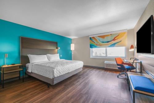 une chambre avec un lit, un bureau et une télévision dans l'établissement Tru By Hilton Lathrop, à Lathrop