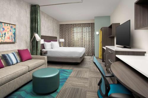 a hotel room with a couch and a bed at Home2 Suites By Hilton Denver Northfield in Denver
