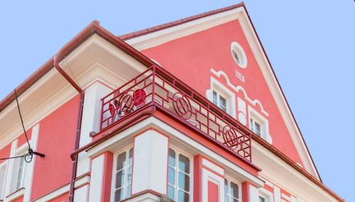 a red and white building with a balcony at Vila Potštejn in Potštejn