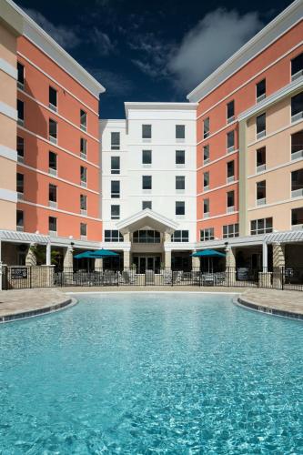 a swimming pool in front of a hotel at Home2 Suites By Hilton Cape Canaveral Cruise Port in Cape Canaveral