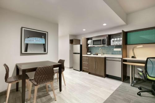a kitchen and dining room with a table and chairs at Home2 Suites By Hilton Norfolk Airport in Norfolk