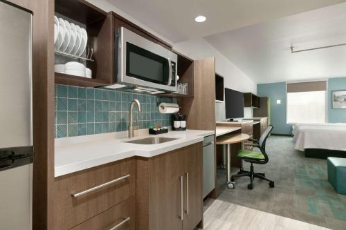 a kitchen with a sink and a bed in a room at Home2 Suites By Hilton Norfolk Airport in Norfolk