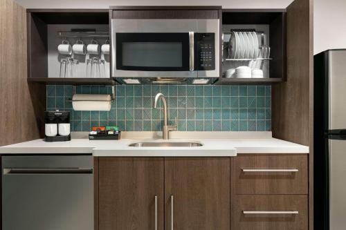 a kitchen with a sink and a microwave at Home2 Suites By Hilton Norfolk Airport in Norfolk