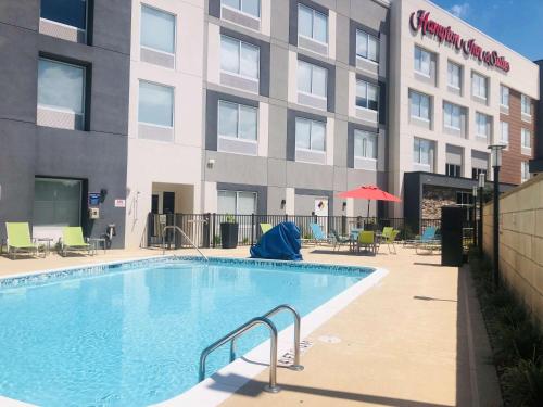 a large swimming pool in front of a building at Hampton Inn & Suites Charlotte North I 485 in Charlotte