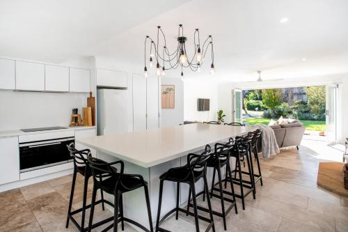 a kitchen with a large white table and chairs at Bawley Point Oasis - Steps from Bawley Beach in Bawley Point