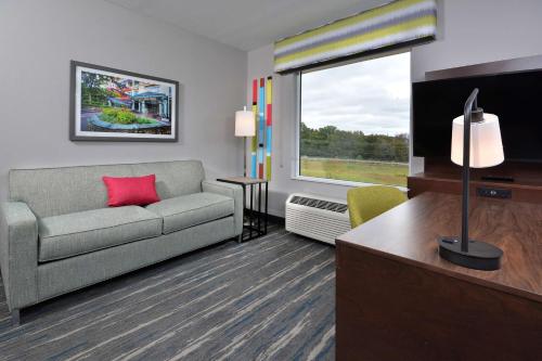 a living room with a couch and a large window at Hampton Inn & Suites Charlotte North I 485 in Charlotte
