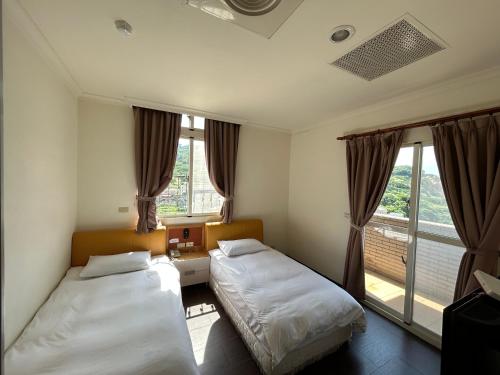 富喜民宿二館 في نانجان: غرفة نوم بسريرين ونافذة