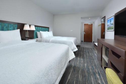 a hotel room with two beds and a flat screen tv at Hampton Inn & Suites Charlotte North I 485 in Charlotte