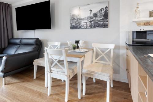 a kitchen and living room with a table and chairs at Boutique Apartment Anybody in Gaienhofen