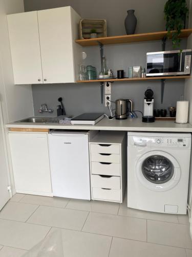 uma cozinha com uma máquina de lavar roupa e um lavatório em BergOne em Ytri-Njarðvík
