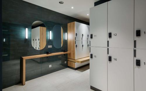 a bathroom with a sink and two mirrors on the wall at Hampton By Hilton Krasnodar in Krasnodar