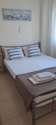 łóżko z niebiesko-białymi poduszkami w obiekcie Gavrihl home w mieście Kawala