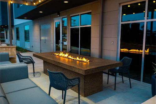 a fireplace on a patio with chairs and a table at Hampton Inn & Suites Imperial Beach San Diego, Ca in Imperial Beach