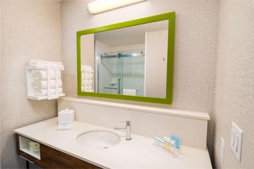 a bathroom with a sink and a green mirror at Hampton Inn & Suites Imperial Beach San Diego, Ca in Imperial Beach
