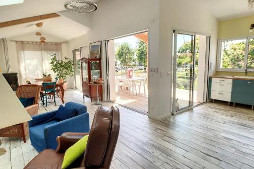 un salon avec un canapé bleu et une cuisine dans l'établissement Très belle villa d'architecte à 30 m de la plage, à Andernos-les-Bains