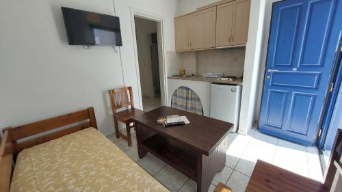 a small kitchen with a table and a blue door at Olympic Villas in Oia