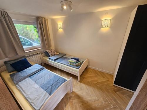 a small bedroom with a bed and a window at Leśne Apartamenty in Hel