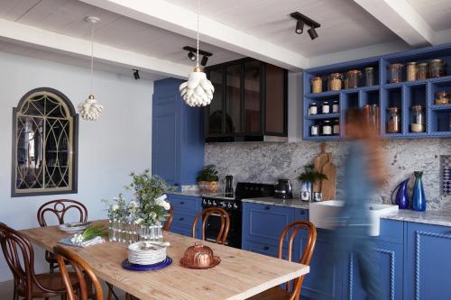 cocina con armarios azules y mesa de madera en Maisons 322 - La Secrète, en Le Bois-Plage-en-Ré