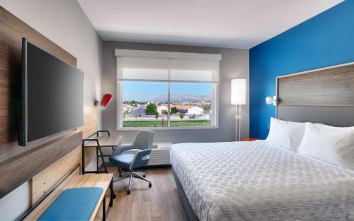a hotel room with a bed and a flat screen tv at Tru By Hilton Clearfield Hill Air Force Base, Ut in Clearfield