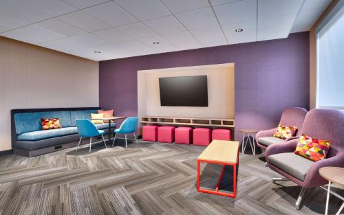a waiting room with chairs and a flat screen tv at Tru By Hilton Clearfield Hill Air Force Base, Ut in Clearfield