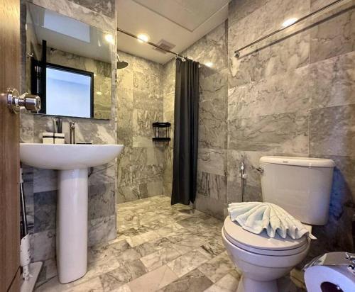 Un baño con un inodoro blanco y un lavabo. en Great mountain view apartment, Pearl 504, en Rawai Beach