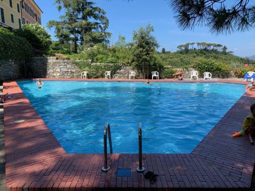 a large swimming pool with blue water at Beautiful house with lovely sea view terrace in Camogli