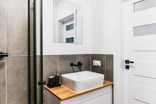 a bathroom with a white sink and a shower at Witosa View in Kraków