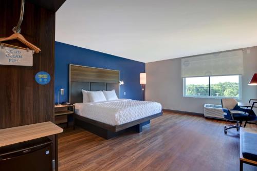 a bedroom with a bed and a blue wall at Tru By Hilton Fort Mill, Sc in Fort Mill