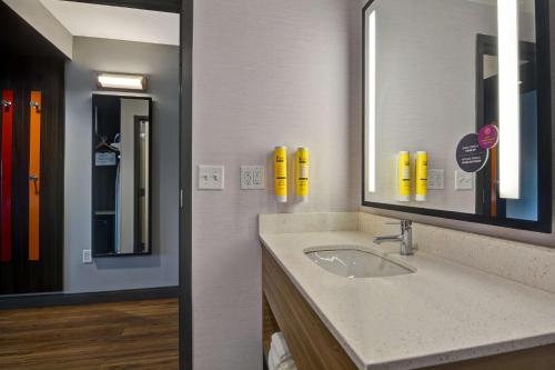 La salle de bains est pourvue d'un lavabo et d'un miroir. dans l'établissement Tru By Hilton Fort Mill, Sc, à Fort Mill