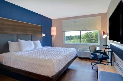 Cette chambre comprend un lit, un bureau et une fenêtre. dans l'établissement Tru By Hilton Fort Mill, Sc, à Fort Mill