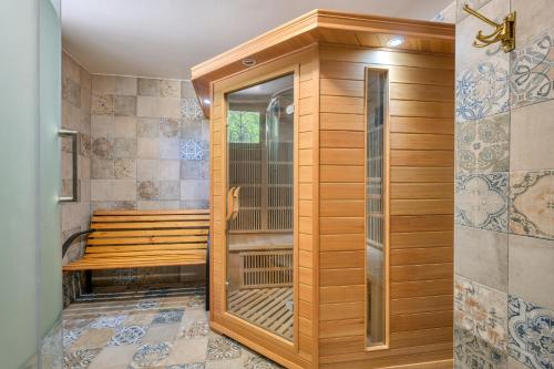 a sauna with a wooden shower stall in a room at Le Petit Château de Barbizon au Bois du Mée in Barbizon