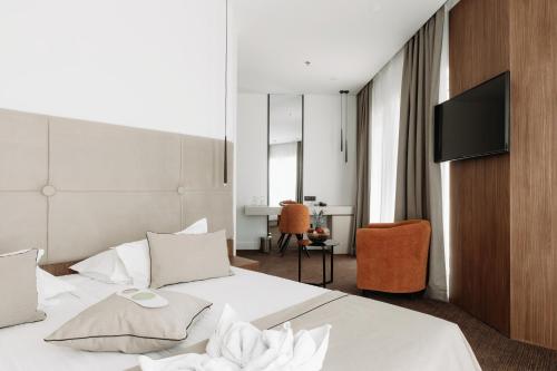 a hotel room with a bed and a flat screen tv at Hotel Fanat in Split