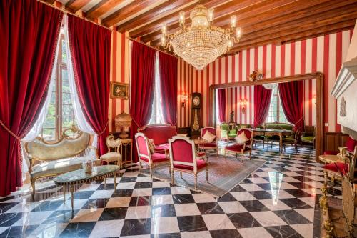 バルビゾンにあるLe Petit Château de Barbizon au Bois du Méeのリビングルーム(赤いカーテン、シャンデリア付)