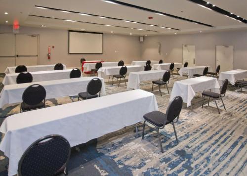 a conference room with white tables and chairs and a screen at Doubletree By Hilton Chico, Ca in Chico