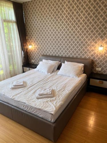 a bed with white sheets and pillows in a bedroom at Sausoji Apartment in Druskininkai
