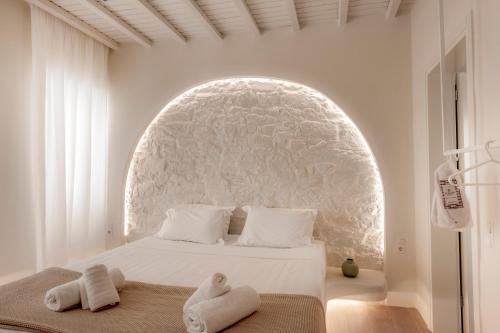 a white bedroom with a white bed with an archway at White Suites in Ermoupoli
