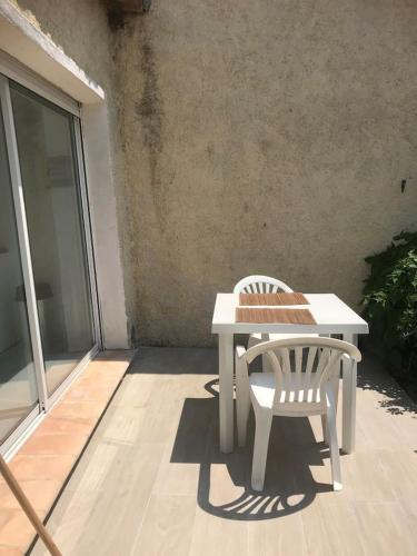 une table blanche et une chaise sur la terrasse dans l'établissement studio centre ville avec jardin, à Sainte-Maxime
