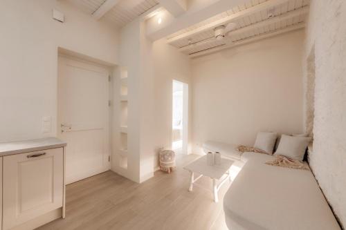 a white living room with a couch and a table at White Suites in Ermoupoli