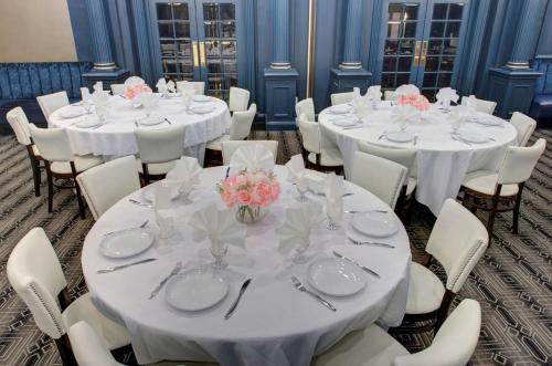 a room with white tables and chairs with flowers on them at The Roslyn, Tapestry Collection by Hilton in Roslyn
