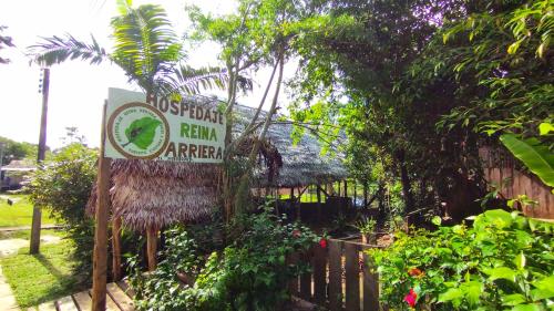Un cartel que anuncia un jardín de lluvia cerca de una valla. en Hospedaje y tours Reina Arriera amazonas colombia, en Macedonia