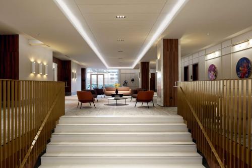 a lobby with stairs and a table and chairs at Homewood Suites By Hilton Montreal Midtown in Montréal