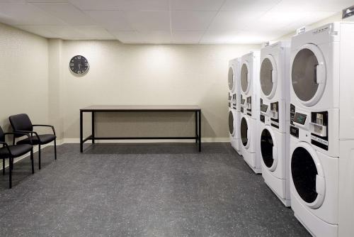 a laundry room with a table and washing machines at Homewood Suites By Hilton Montreal Midtown in Montréal