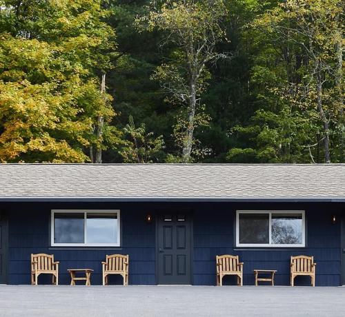 a blue building with four chairs in front of it at Eastwind in Windham