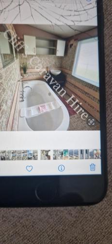 uma imagem de uma casa de banho com banheira num quarto em Cliffs caravan hire em Gisburn